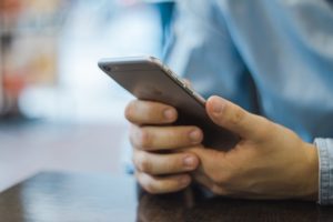 A man checks his the email marketing in his inbox on his mobile device.