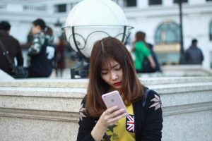 A woman watches video content on her mobile device.